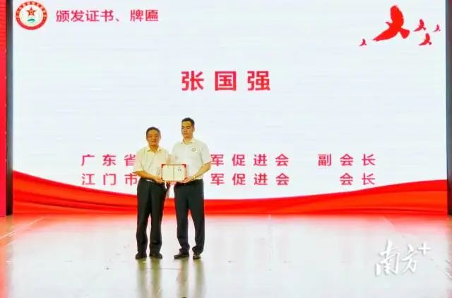 广东省爱国拥军促进会会长张小棣为张国强颁发广东省爱促会副会长证书和江门市爱促会会长牌匾。 南方+ 申红洲 拍摄 图片