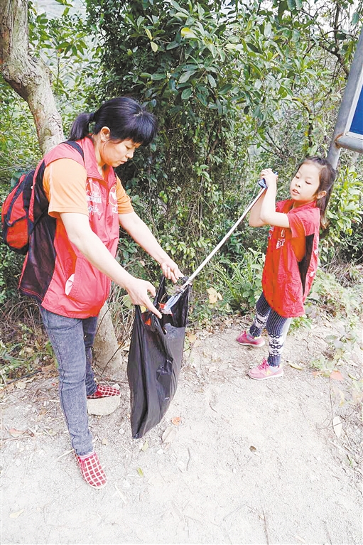 你来捡,我来装,当志愿者从小事做起,从小做起。江门日报记者 你来捡,我来装,当志愿者从小事做起,从小做起。江门日报记者